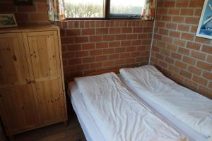 una cama en una habitación con una pared de ladrillo en Rekerlanden 161, en Schoorldam 19 fotos más
