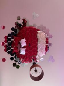 Una pared hecha de flores y un reloj en Suite L'echappee - Maison romantique - SPA & Sauna Privatif- Pole Dance - Lit rond avec miroir au plafond, en Pézarches