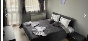 Un dormitorio con una cama con arcos blancos. en Ski Apartment Boyika Iglika 2 en Borovets