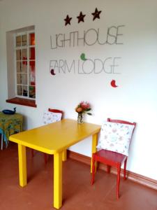 a wooden table topped with a blue and white striped tablecloth at Lighthouse Farm Backpackers Lodge in Cape Town