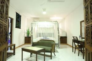 a living room with a chair and a table at Bougain Villa in Bentota