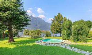 una piscina nel mezzo di un cortile con un albero di Villa Giù Luxury - The House Of Travelers a Faggeto Lario