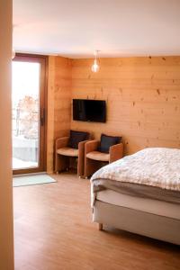a bedroom with a bed and a flat screen tv at Chambre privée avec cuisine et salle de bain dans la chambre, Winoka Lodge in Veysonnaz