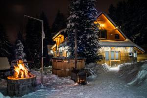 a fire pit in front of a house in the snow at Sielankowo-dom na wyłączność in Istebna