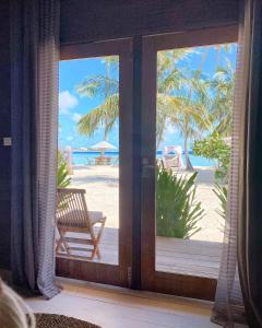 a room with a door open to the beach at Met House in Thulusdhoo