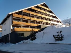 un grande edificio con neve di fronte di La Prada - 2 Zimmerwohnung mit 40m2 für max. 3 Personen a Laax
