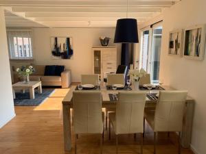 a dining room and living room with a table and chairs at Vakantiewoning aan het Veerse meer in Wolphaartsdijk
