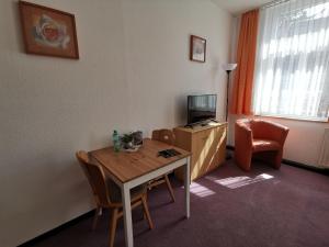 een kamer met een tafel en stoelen en een televisie bij Pension zum Hirsch in Hattersheim