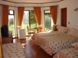 a hotel room with two beds and a television at Hotel Victoria in Hanga Roa