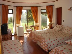 um quarto de hotel com duas camas e uma televisão em Hotel Victoria em Hanga Roa