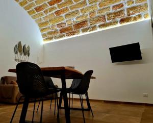 un tavolo e sedie in un soggiorno con muro di mattoni di SCRUSCIU HOME a Terrasini