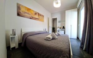 una camera da letto con un letto con asciugamani sopra di SCRUSCIU HOME a Terrasini