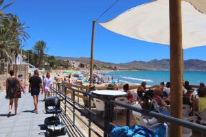 a crowd of people walking along a beach at El Alamillo seaview Penthouse in Mazarrón