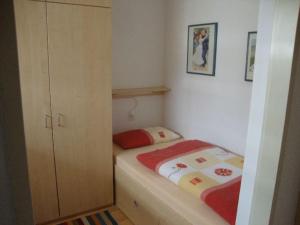 um pequeno quarto com uma cama e um armário em La Prada - 2 Zimmerwohnung mit 40m2 für max. 3 Personen em Laax