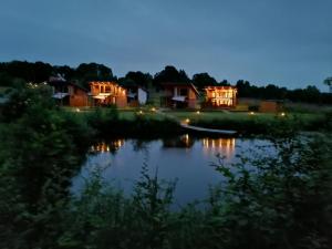 un grupo de casas a orillas de un río en Rezerwat Wielin, en Wielin
