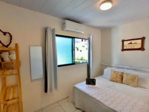 a bedroom with a bed and a window at Pousada America do Sol in Natal