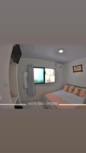 Cette petite chambre comprend un lit et une fenêtre. dans l'établissement Pousada America do Sol, à Natal