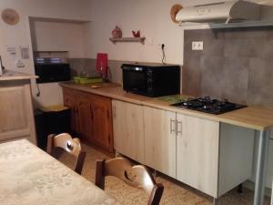 a kitchen with a counter with a stove and a microwave at Maison De Vacances in Blondefontaine