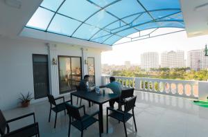 dos personas sentadas en una mesa en un balcón en Korea Hotel Bac Giang, en Làng Thành