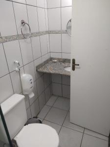 a white bathroom with a toilet and a sink at Pousada Espirito do Mar in Cabo Frio