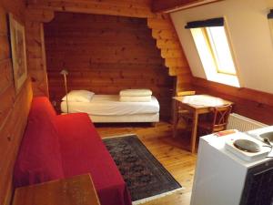 um pequeno quarto com uma cama num chalé de madeira em Pension Groenewoud appartementen vrijdag tot maandag en maandag tot vrijdag em Swalmen