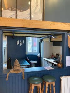 a room with two stools and a counter with a kitchen at Appartement magique des sorciers , centre historique Dijon in Dijon