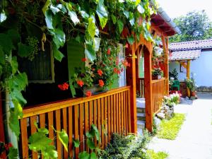 a house with a wooden fence with flowers on it at Relax Nyaralóudvar in Szilvásvárad