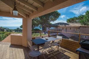 un patio avec une table et des chaises sur une terrasse dans l'établissement Santa Giulia - Le village de L'hacienda, à Porto-Vecchio
