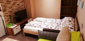 - une petite chambre avec un lit et une télévision dans l'établissement Erika Vendégház, à Mogyoród