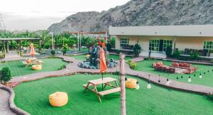 a playground in front of a building with a mountain at Hidden Valley Farm Home AE in Bulaydah