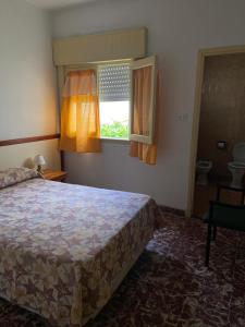 a bedroom with a bed and a window at Hotel Roma in Mar de Ajó