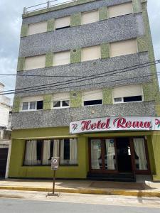 a building with a hotel room sign in front of it at Hotel Roma in Mar de Ajó