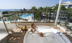 a woman sitting in a bath tub on a balcony at Rai Premium Tekirova - Ex Queen's Park Tekirova in Tekirova