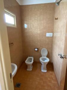 a bathroom with a toilet and a bidet at Hotel Roma in Mar de Ajó