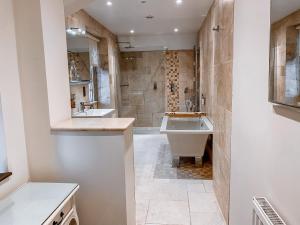 a bathroom with a tub and a sink and a shower at The Northey Arms in Box