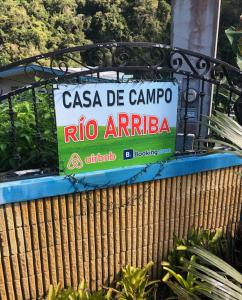 un cartello sopra una recinzione di legno di Casa de Campo Rio Arriba a Arecibo