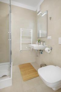e bagno con servizi igienici, lavandino e doccia. di Cliché Luxury Apartment a Braşov