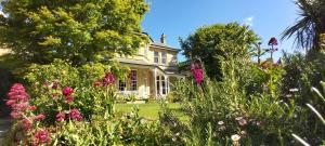 a house with a garden of flowers in front of it at Clarence House Apartments in Ventnor