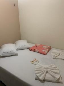 een wit bed met 2 kussens en handdoeken erop bij Apartamento Central in Guaramiranga