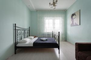 モスクワにあるGrand Apart Putilkovoのベッドルーム1室(青い壁のベッド1台、窓付)