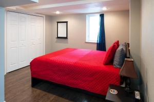 a bedroom with a red bed and a window at The Lewis House in Laramie