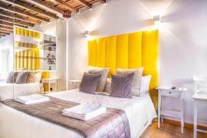 - une chambre avec un grand lit et une tête de lit jaune dans l'établissement Fontana di Trevi Diamond Boutique, à Rome