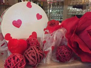 une table recouverte de coeurs rouges et de roses rouges dans l'établissement Hotel Cajou, à La Panne