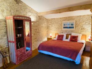 a bedroom with a large bed and a mirror at La Barauderie , chambre individuelle in Mazeray