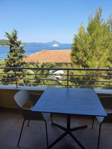 a blue table on a balcony with a view of the ocean at Apartmaji Punta in Veli Lošinj