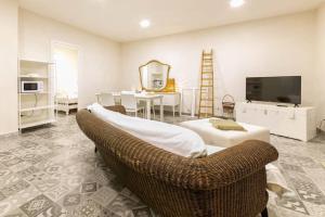 uma sala de estar com uma televisão, um sofá e uma mesa em Villa Ferrante em Marina di Ragusa