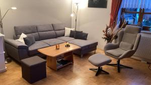 a living room with a couch and two chairs and a table at Apartment See und Traunsteinblick in Altmünster