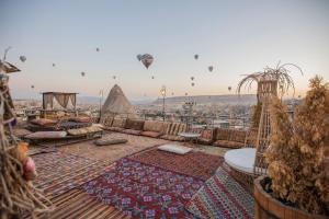 a view of a rooftop with hot air balloons in the sky at Divan Cave House in Göreme