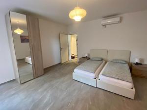een slaapkamer met 2 bedden en een grote spiegel bij Appartamento Lungolago in Locarno