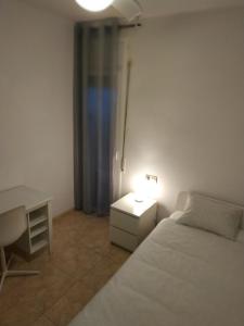 een slaapkamer met een bed, een bureau en een lamp bij RMM27 - Piso en zona tranquila de Tortosa in Tortosa